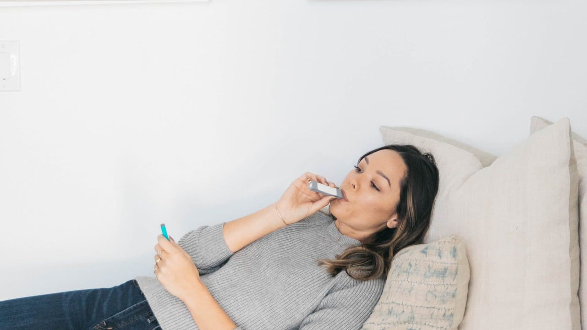 Person on a daybed exhaling through a personal smoke filter