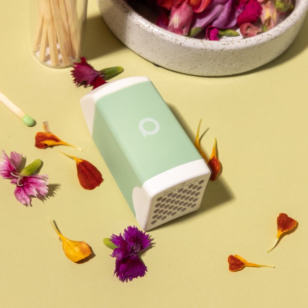 Sage PHREND personal smoke filter on a yellow table with flower petals